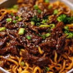 Sticky soy-garlic beef stir fry with vibrant vegetables and noodles in a white bowl Title: Sticky Soy-Garlic Beef Stir Fry