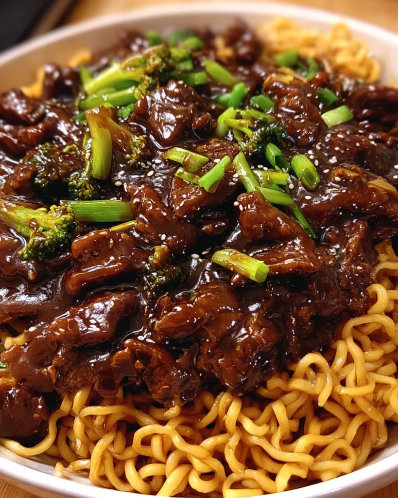 Sticky soy-garlic beef stir fry with vibrant vegetables and noodles in a white bowl Title: Sticky Soy-Garlic Beef Stir Fry