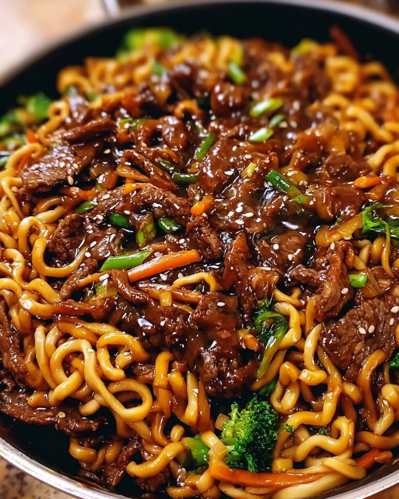 Sticky soy-garlic beef stir fry with vibrant vegetables and noodles in a white bowl Title: Sticky Soy-Garlic Beef Stir Fry