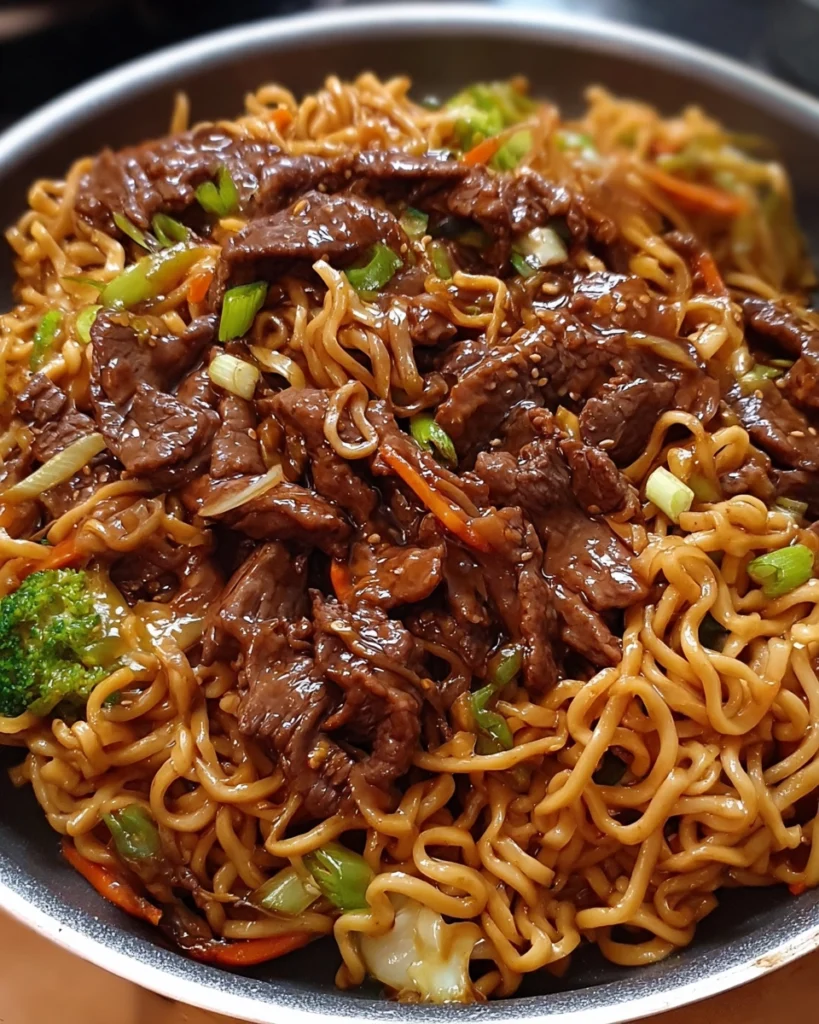 Sticky soy-garlic beef stir fry with vibrant vegetables and noodles in a white bowl Title: Sticky Soy-Garlic Beef Stir Fry