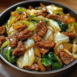 Simple beef and cabbage stir-fry served in a white bowl with garlic soy glaze.