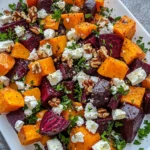Colorful roasted beet and sweet potato salad topped with feta, parsley, and creamy yogurt dressing.