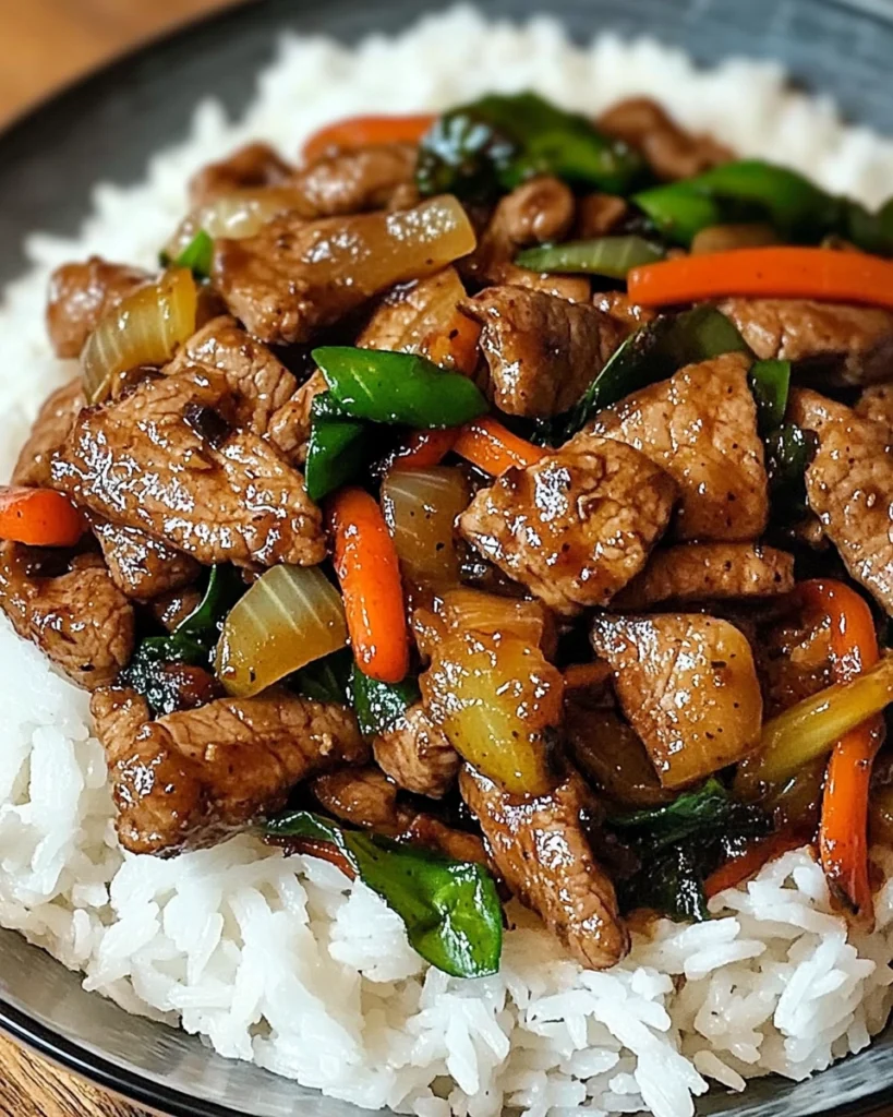 Overhead view of Spicy Thai Basil Beef with Garlic, Peppers & Jasmine Rice, showing vibrant red bell peppers, fresh green Thai basil leaves, and steaming jasmine rice