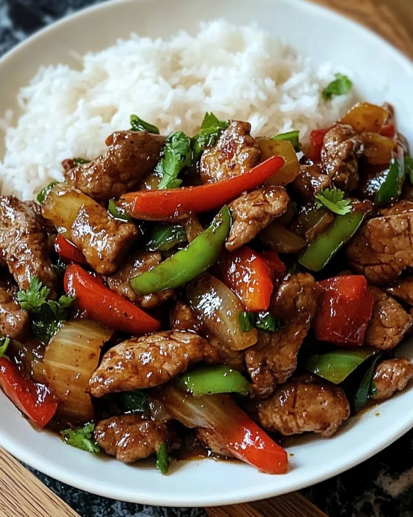 Overhead view of Spicy Thai Basil Beef with Garlic, Peppers & Jasmine Rice, showing vibrant red bell peppers, fresh green Thai basil leaves, and steaming jasmine rice
