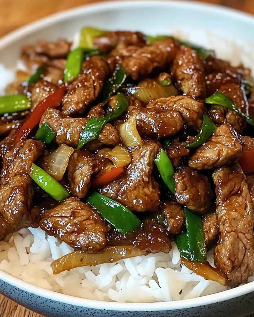Overhead view of Spicy Thai Basil Beef with Garlic, Peppers & Jasmine Rice, showing vibrant red bell peppers, fresh green Thai basil leaves, and steaming jasmine rice